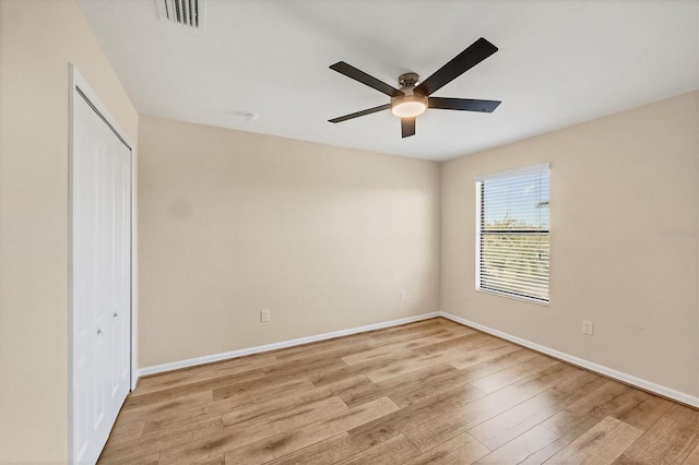 unfurnished bedroom featuring light hardwood / wood-style flooring, a closet, and ceiling fan