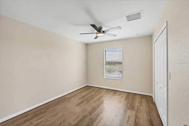 unfurnished bedroom featuring hardwood / wood-style flooring, a closet, and ceiling fan