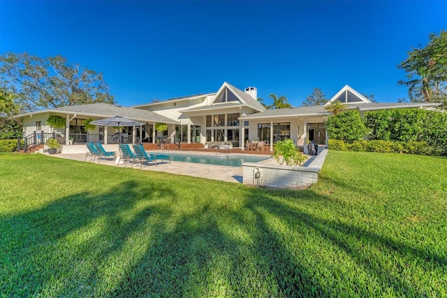 rear view of house with a patio and a lawn