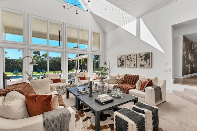 carpeted living room with a chandelier and a high ceiling