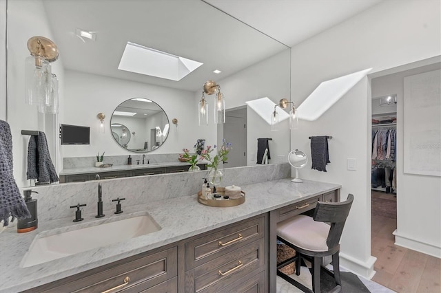 bathroom featuring vanity, a skylight, and hardwood / wood-style floors