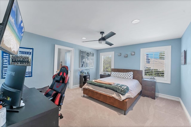 bedroom featuring multiple windows, light colored carpet, and ceiling fan