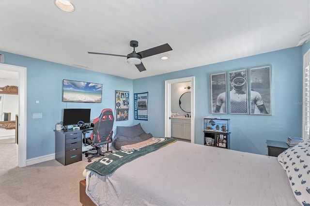 bedroom featuring light colored carpet, ceiling fan, and ensuite bathroom