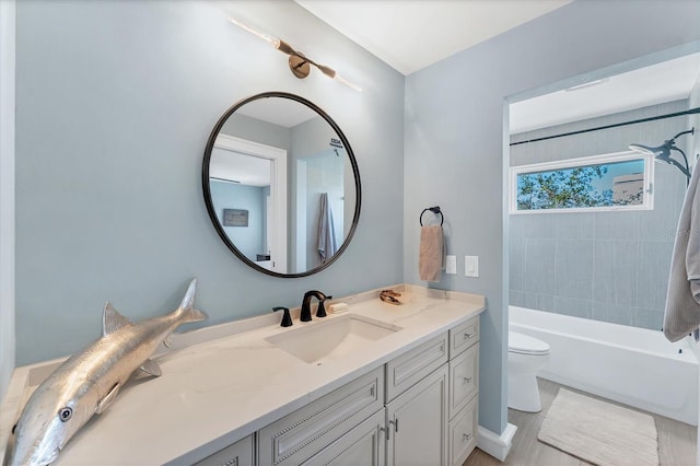 full bathroom featuring vanity, tiled shower / bath, and toilet