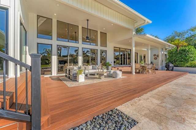 wooden deck with outdoor lounge area, a grill, and ceiling fan