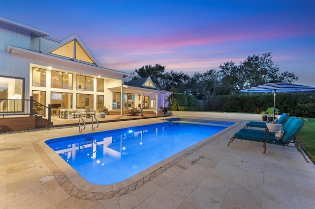 pool at dusk with a patio