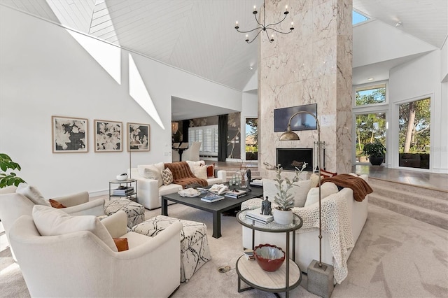 living room with a premium fireplace, high vaulted ceiling, and a notable chandelier