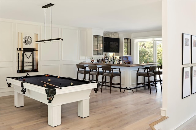 recreation room with billiards, indoor bar, and light hardwood / wood-style flooring