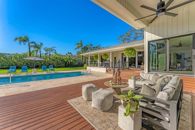 view of pool featuring ceiling fan, outdoor lounge area, and a deck