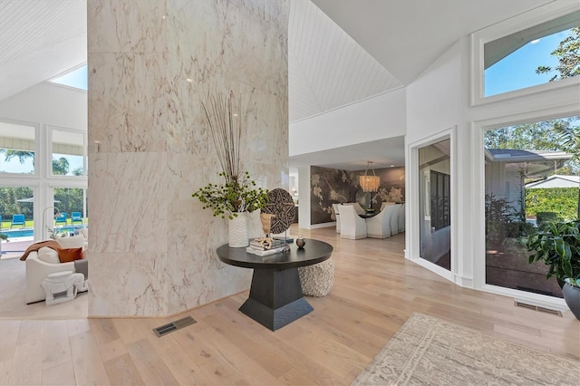 interior space featuring high vaulted ceiling and light hardwood / wood-style floors