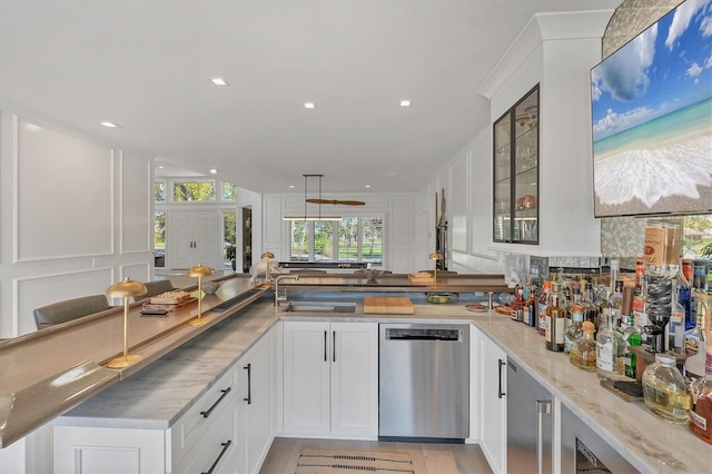 kitchen featuring light stone counters, white cabinetry, dishwasher, and kitchen peninsula