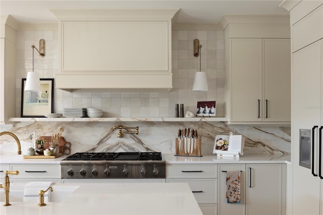 kitchen featuring tasteful backsplash, stainless steel gas stovetop, range, and white cabinets