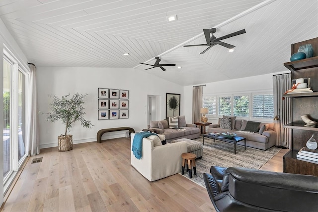 living room with ceiling fan, vaulted ceiling, and light wood-type flooring