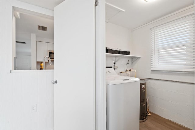 washroom with hardwood / wood-style flooring and washer / dryer