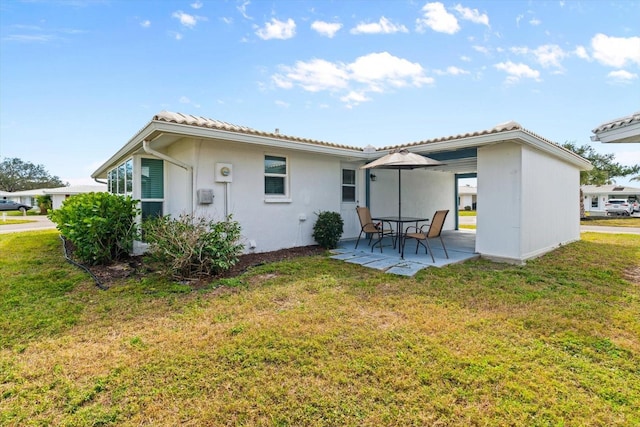 rear view of property featuring a patio and a yard