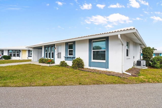 ranch-style home featuring central AC unit and a front yard