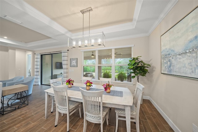 dining room featuring ornamental molding, a tray ceiling, and a chandelier