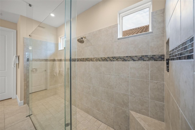 bathroom with an enclosed shower and tile patterned flooring