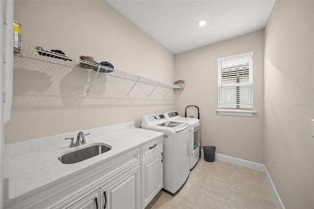 laundry room with cabinets, separate washer and dryer, sink, and light tile patterned floors