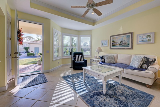 tiled living room featuring a raised ceiling, crown molding, and ceiling fan