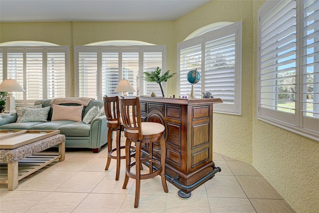 interior space with indoor bar and light tile patterned floors