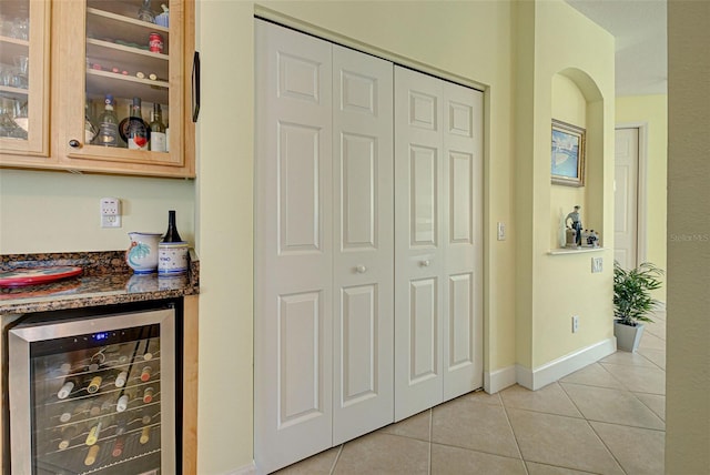 bar with light tile patterned floors, wine cooler, and light brown cabinetry