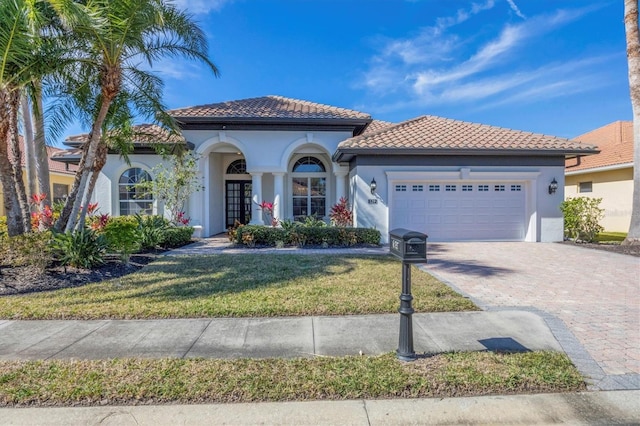 mediterranean / spanish house with a garage and a front lawn