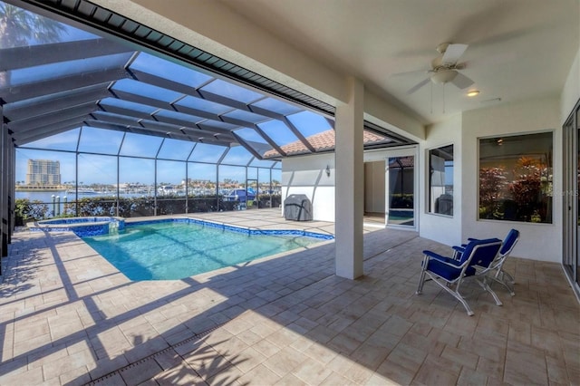 view of pool featuring a patio, an in ground hot tub, a lanai, ceiling fan, and a water view