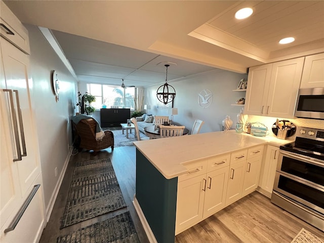 kitchen with white cabinetry, appliances with stainless steel finishes, pendant lighting, and light wood-type flooring