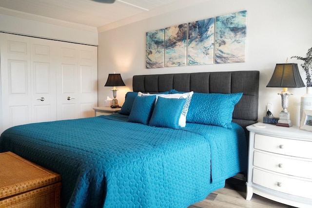 bedroom featuring crown molding, light wood-type flooring, and a closet