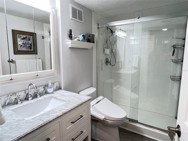 bathroom featuring hardwood / wood-style floors, vanity, an enclosed shower, a textured ceiling, and toilet