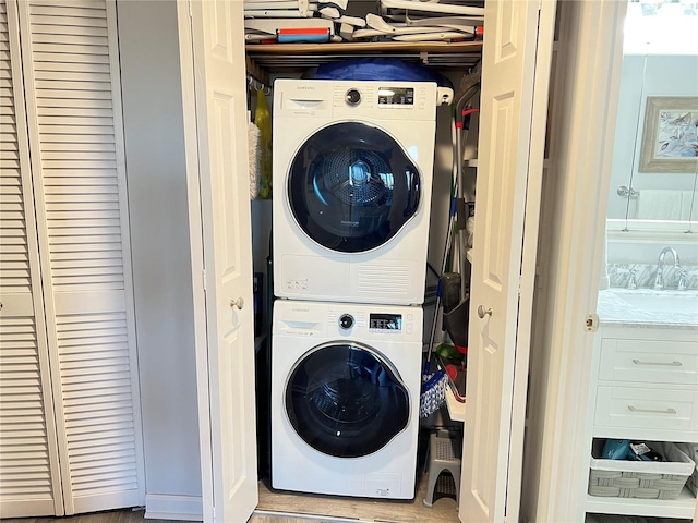 washroom featuring sink and stacked washer / dryer