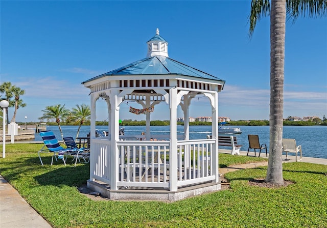 view of property's community with a gazebo, a water view, and a lawn