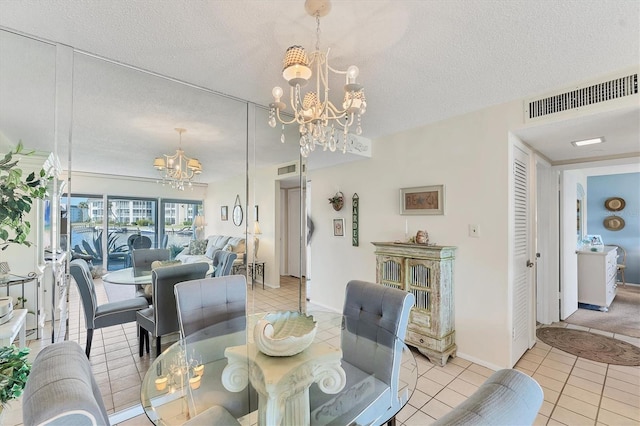 dining space featuring a notable chandelier, light tile patterned floors, and a textured ceiling