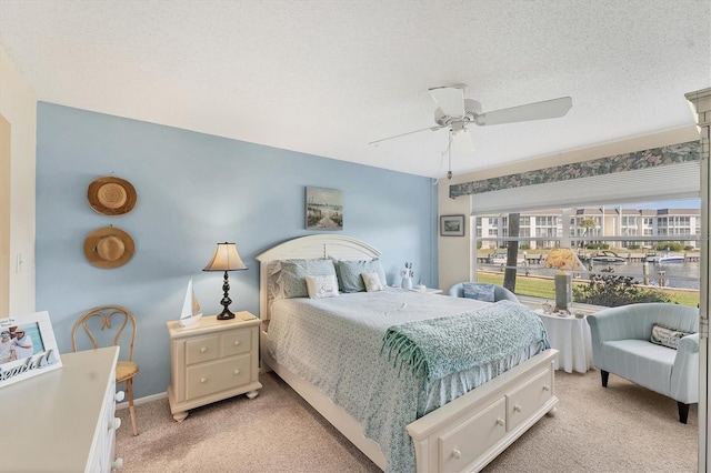 carpeted bedroom with a textured ceiling and ceiling fan