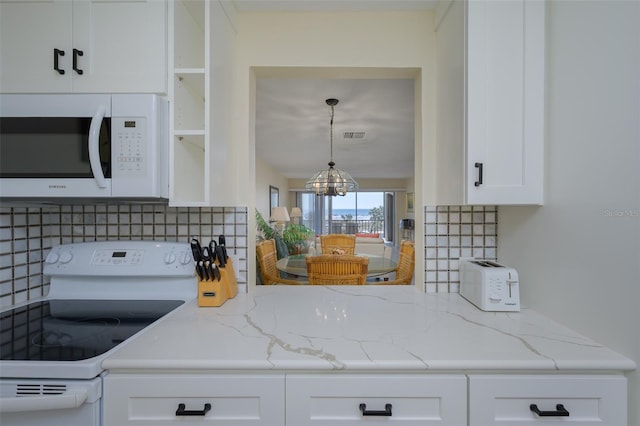 kitchen featuring white cabinetry, white appliances, light stone countertops, and backsplash