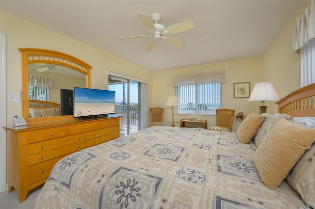 bedroom with ceiling fan, multiple windows, and access to outside