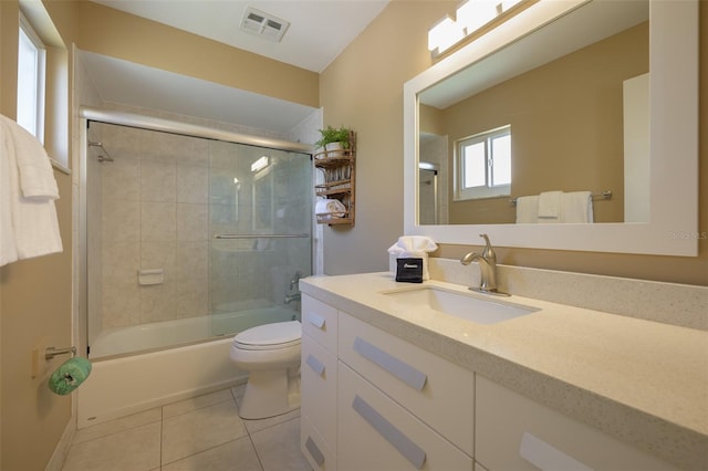 full bathroom featuring tile patterned flooring, enclosed tub / shower combo, vanity, and toilet