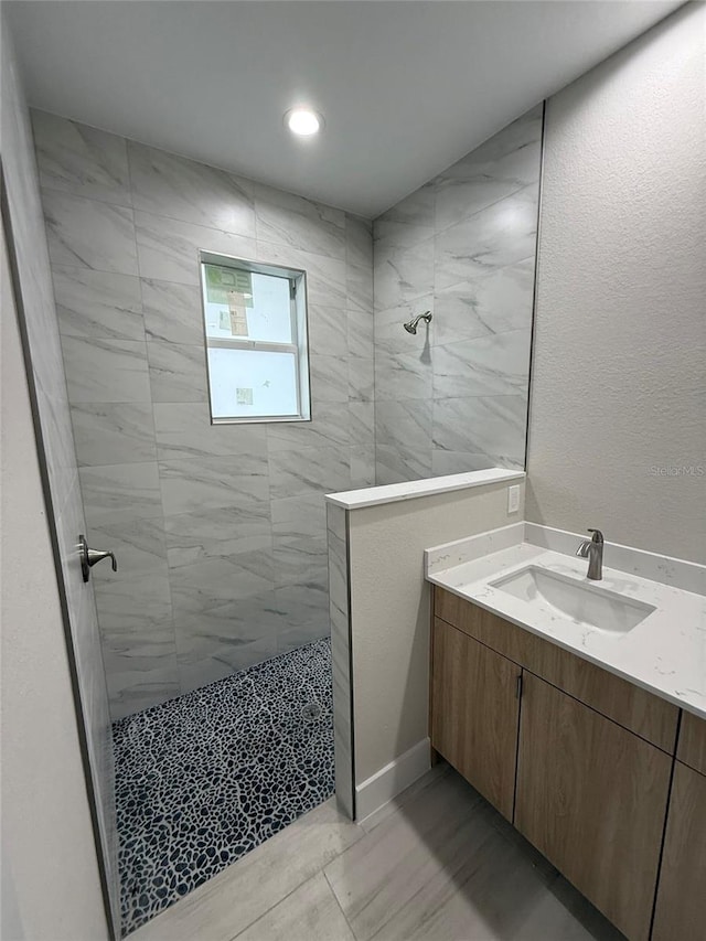 bathroom featuring vanity and a tile shower