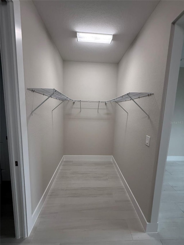 spacious closet with light hardwood / wood-style floors