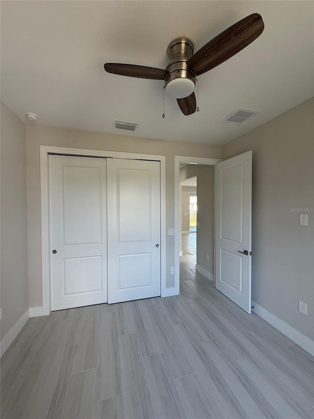 unfurnished bedroom with ceiling fan, a closet, and light hardwood / wood-style flooring