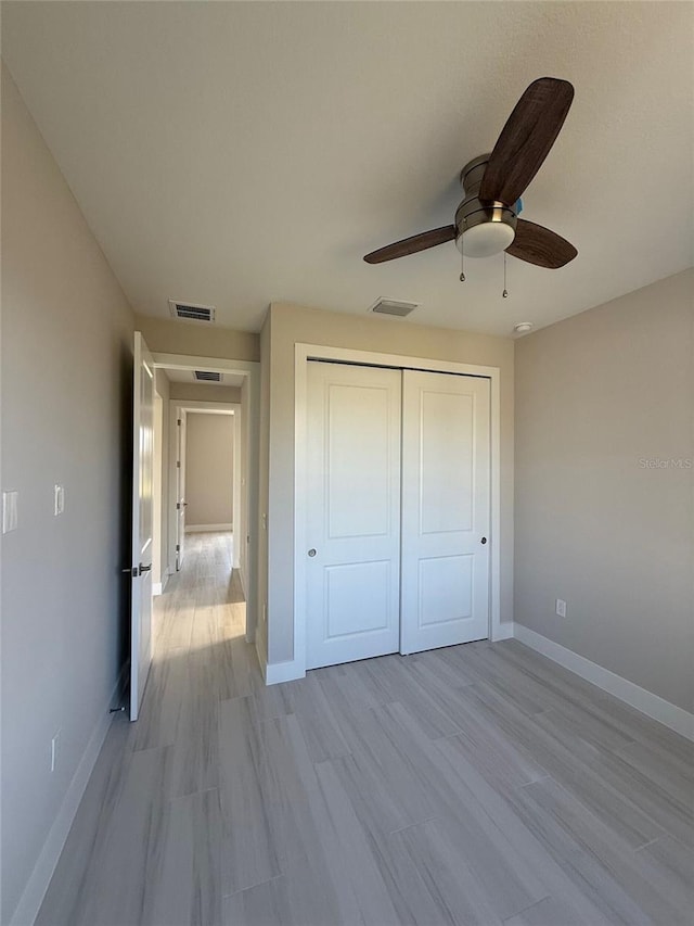 unfurnished bedroom featuring light hardwood / wood-style flooring, a closet, and ceiling fan