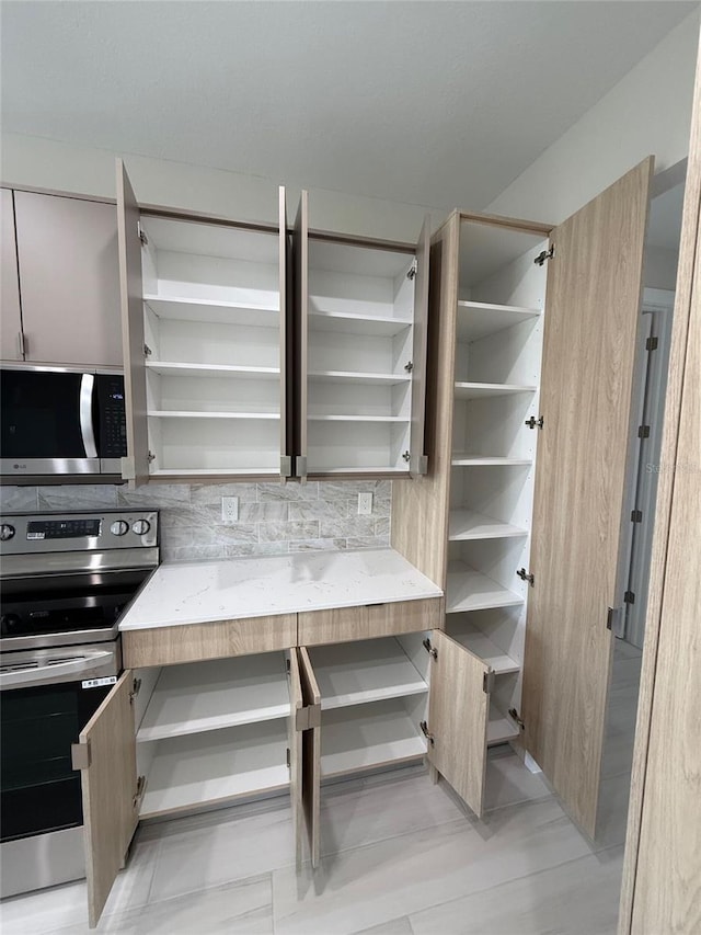 kitchen featuring stainless steel appliances and decorative backsplash