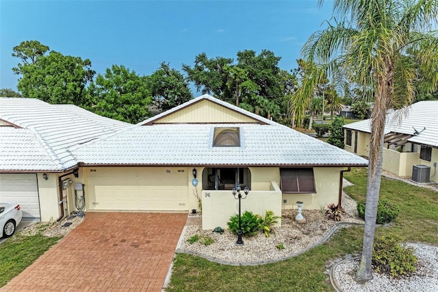 view of front of home featuring a garage and central air condition unit