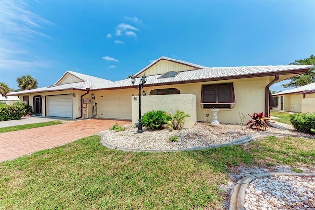 single story home with a garage and a front yard