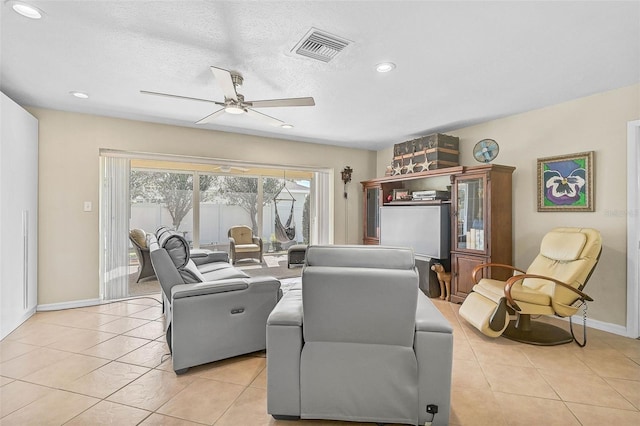 living room featuring ceiling fan, a textured ceiling, and light tile patterned floors