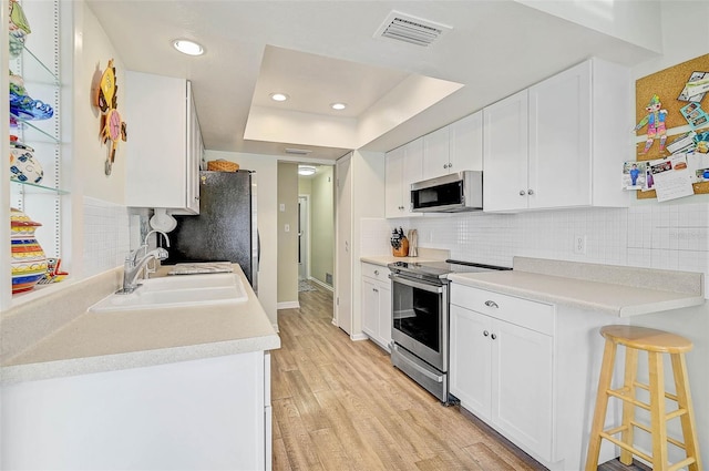 kitchen featuring sink, light hardwood / wood-style flooring, white cabinets, and appliances with stainless steel finishes