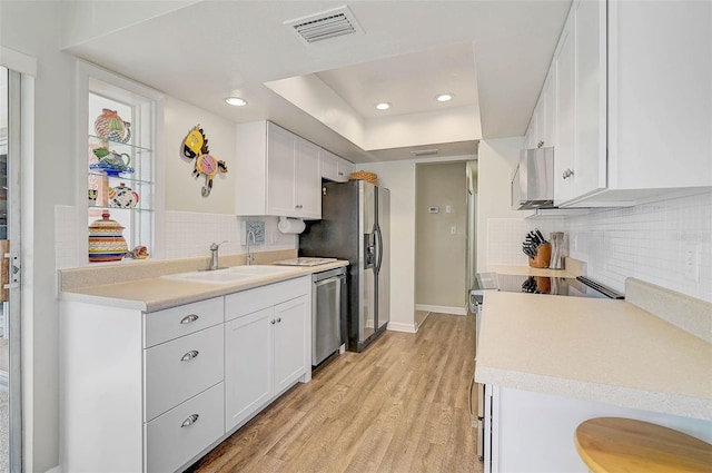 kitchen with white cabinetry, stainless steel appliances, sink, and light wood-type flooring