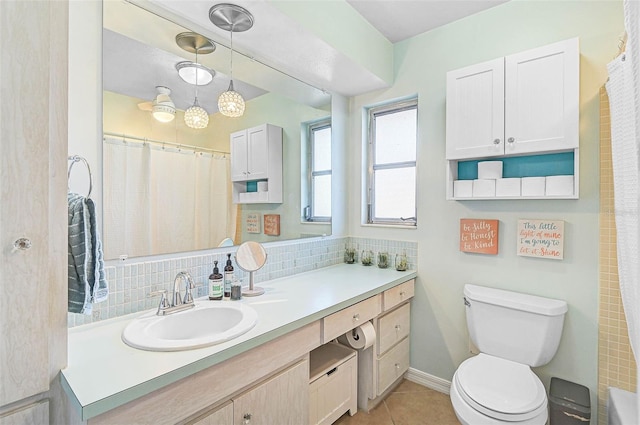 bathroom featuring toilet, vanity, curtained shower, tile patterned flooring, and decorative backsplash