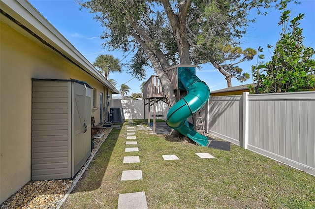 view of yard featuring central AC unit and a playground